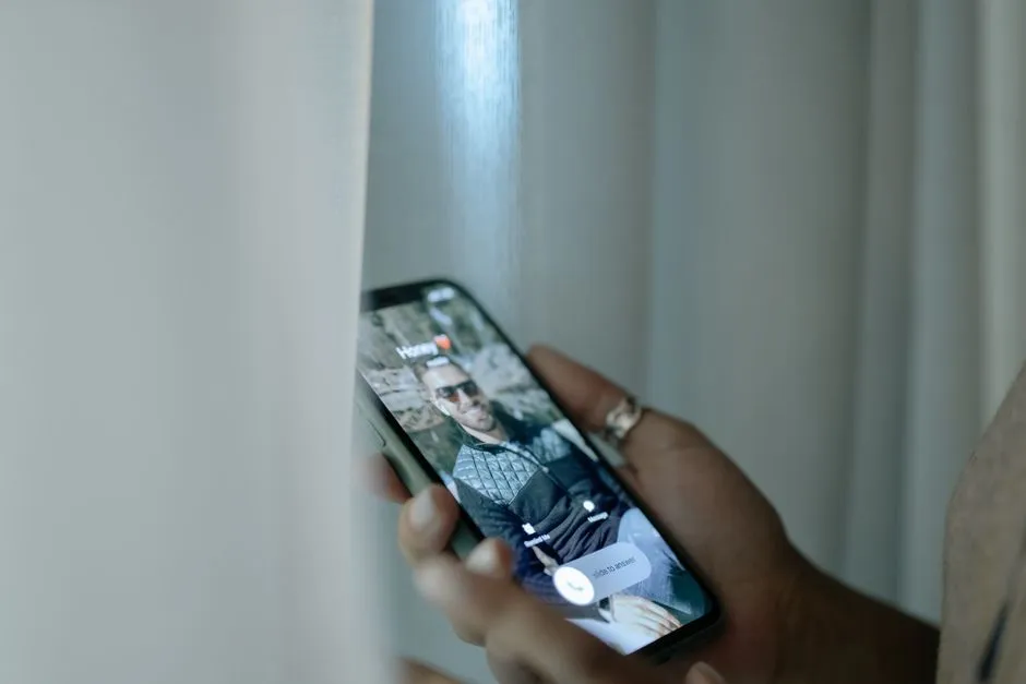 Illustrative close-up photo of a hand holding a smartphone showing an incoming call notification