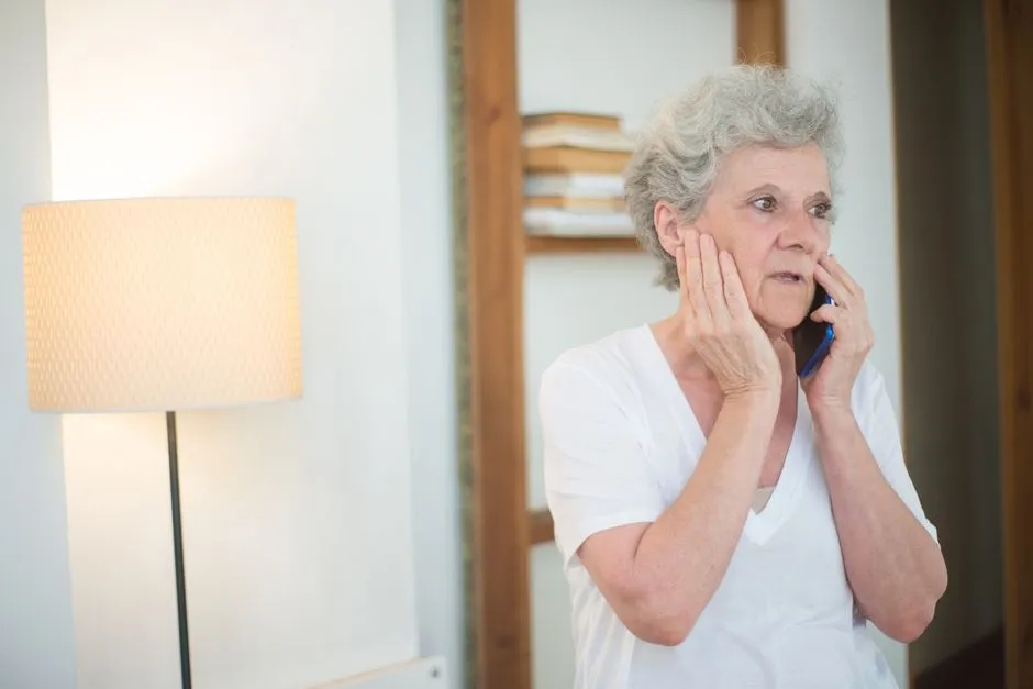Illustrative photo of an older adult looking concerned while talking on the phone, representative of a common Social Security scam target